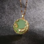 Green jade koi fish lotus necklace pendant close-up with gold embossed details on dark background