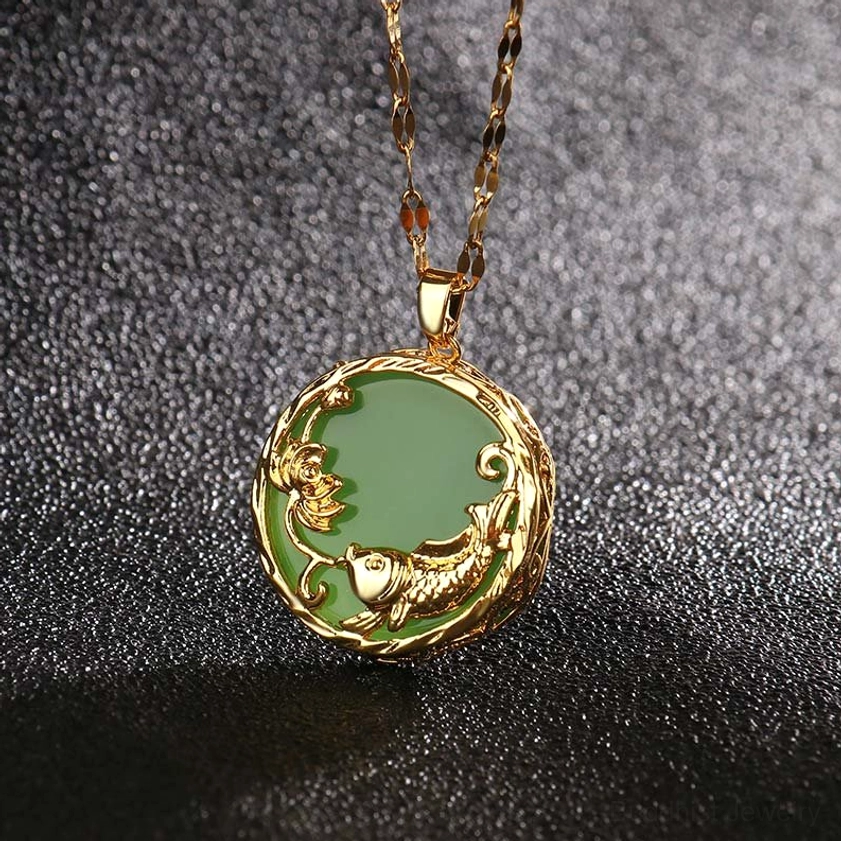Green jade koi fish lotus necklace pendant close-up with gold embossed details on dark background