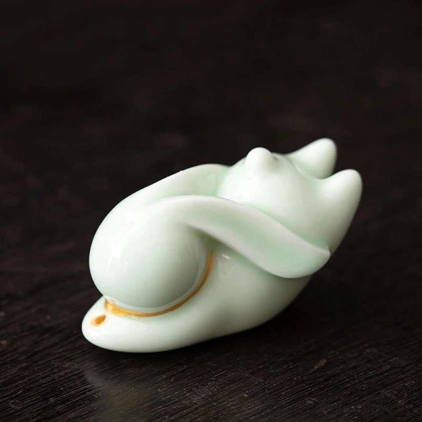 Green ceramic rabbit incense burner on blue floral bamboo mat with incense for mindfulness