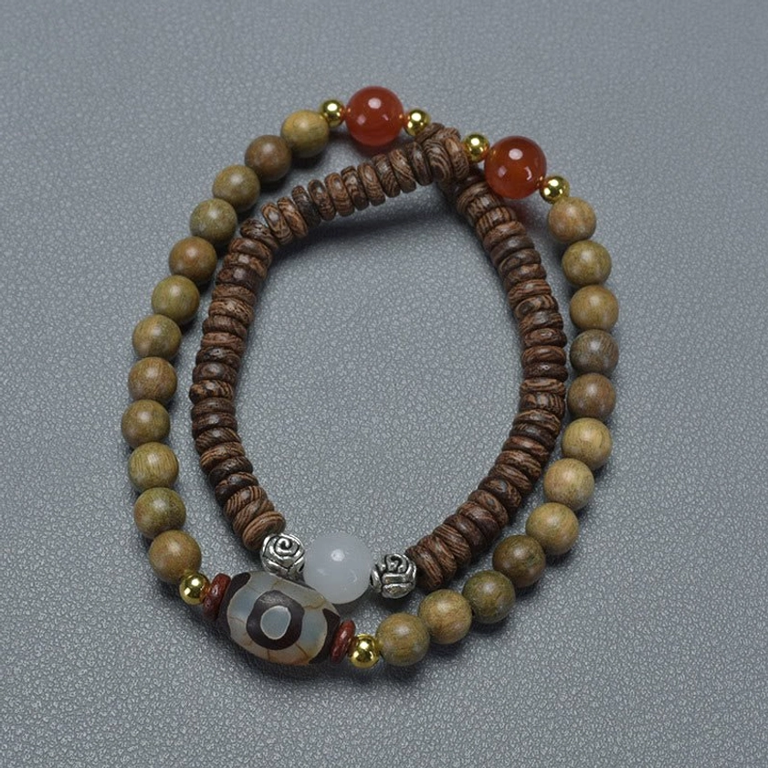 Full view of green sandalwood Buddhist double wrap bracelet showing natural wood grain texture and rich color with dzi bead centerpiece
