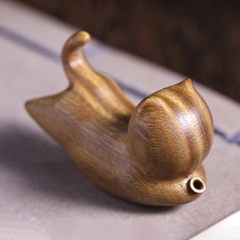 Close-up right side view of handmade green sandalwood cat incense burner, highlighting clear wood grain stripes, curled tail, and metal port