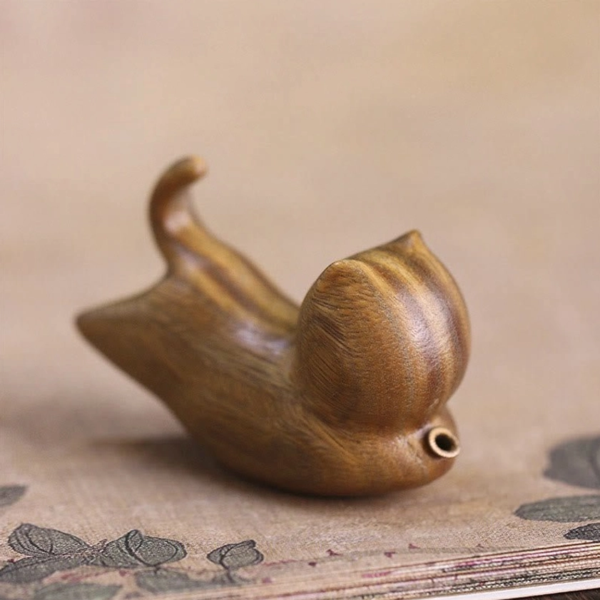 Handcrafted green sandalwood cat incense burner, front top view displaying metal incense socket, striped wood texture, and curled tail design