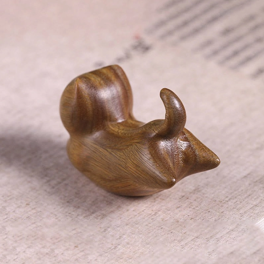 Handmade green sandalwood cat-shaped incense burner, left front angle showcasing smooth wood surface, pointed snout, and decorative curled tail