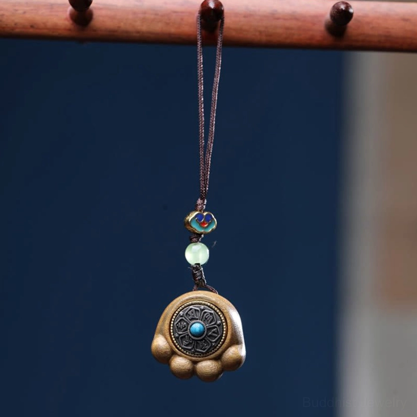 Green sandalwood cat paw phone hanging with enamel cloud bead, jade spacer, and turquoise-inlaid metal charm on display
