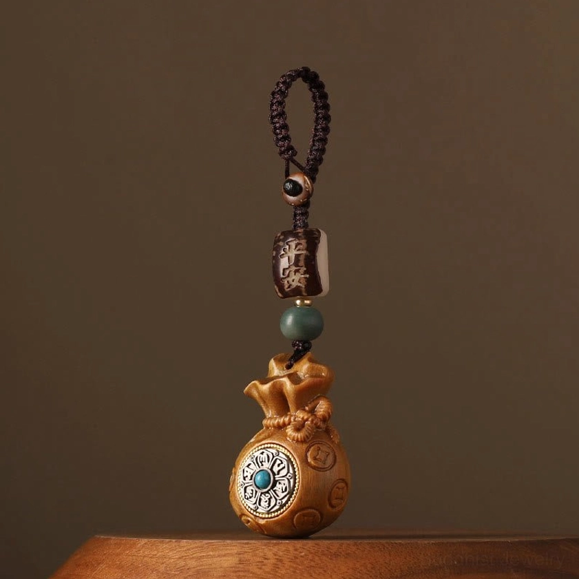 Green sandalwood money bag Buddhist charm showing light yellow-brown wood color with rotatable turquoise-inlaid charm and matching bead set