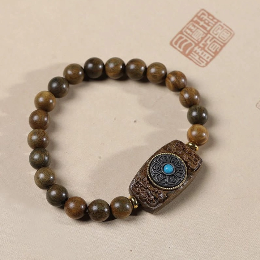Green sandalwood Buddhist bracelet with carved mantra charm and blue inlay, premium quality display