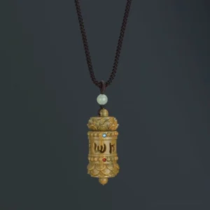 Green sandalwood Om Mani Padme Hum Buddhist prayer wheel pendant necklace with carved mantra script and lotus design on dark background