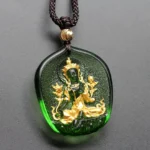 Green Tara Buddha gold-plated liuli crystal pendant necklace front view with golden halo and embossed seated Buddha relief on dark green crystal