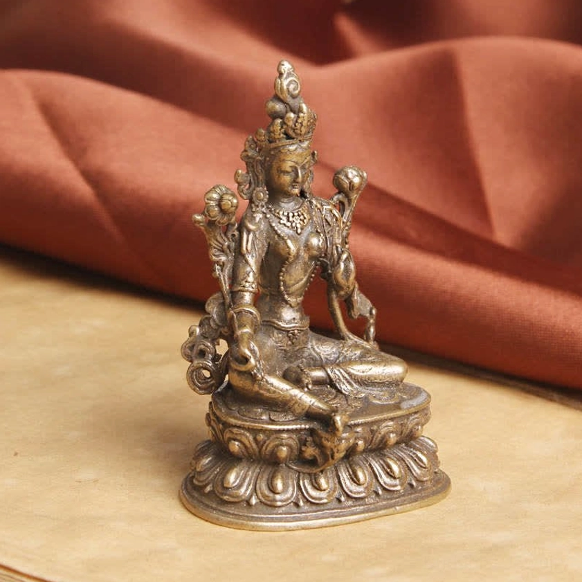 Green Tara Buddhist statue three-quarter side angle showing detailed ornaments and aged bronze finish
