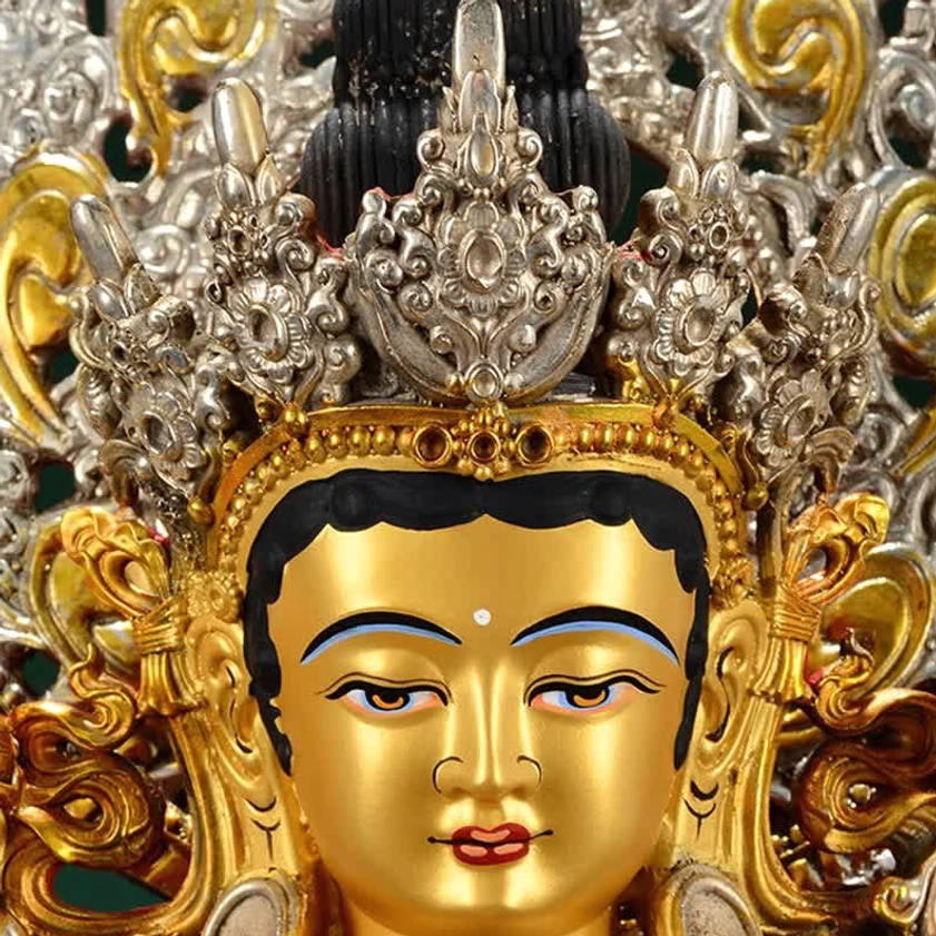 Close-up of Green Tara Bodhisattva's face showing gilt golden features, silver filigree crown, and hand-painted details