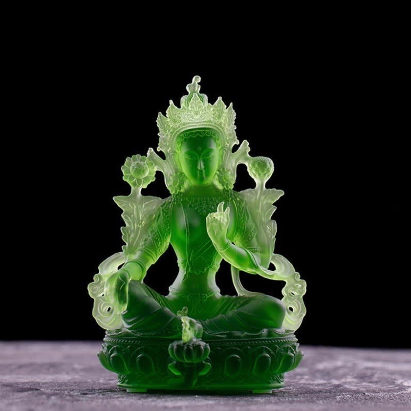 Green Tara Buddha statue front full view on dark background, solid translucent deep green with traditional Buddhist lotus base
