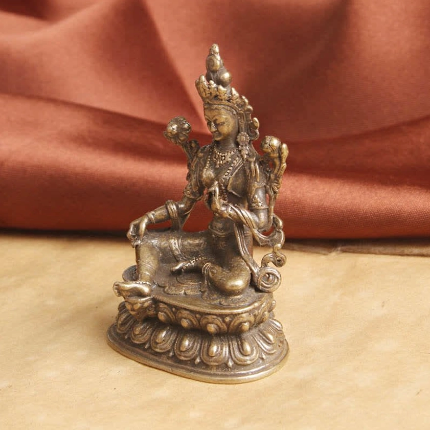 Green Tara Buddhist statue side three-quarter view showing different hand posture and aged bronze texture
