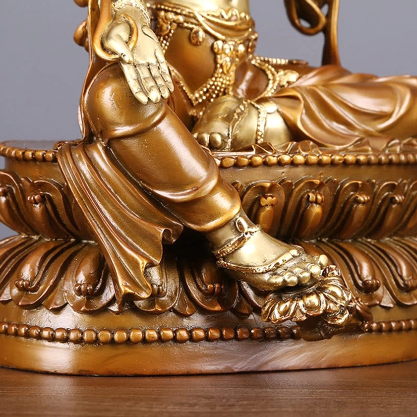 Green Tara lower body and lotus base close-up - carved lotus throne, draped robe texture, and foot placement