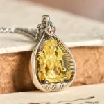 Green Tara Buddhist pendant necklace with copper and silver materials, displaying intricate bodhisattva design on wooden surface