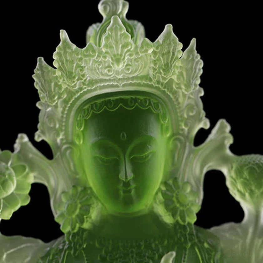 Green Tara Buddha statue head close-up showing intricate carved crown, serene facial features, translucent deep green crystal