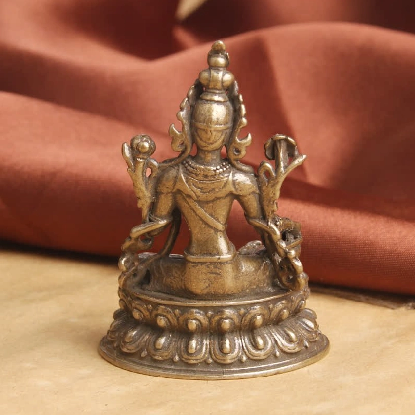 Green Tara statue rear view on vintage background showing back sculptural details and lotus base