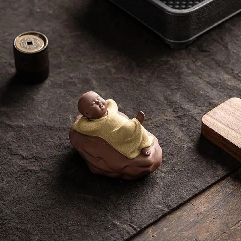 Grey ceramic monk statue interior home decor display on shelf with mindfulness ambient setup