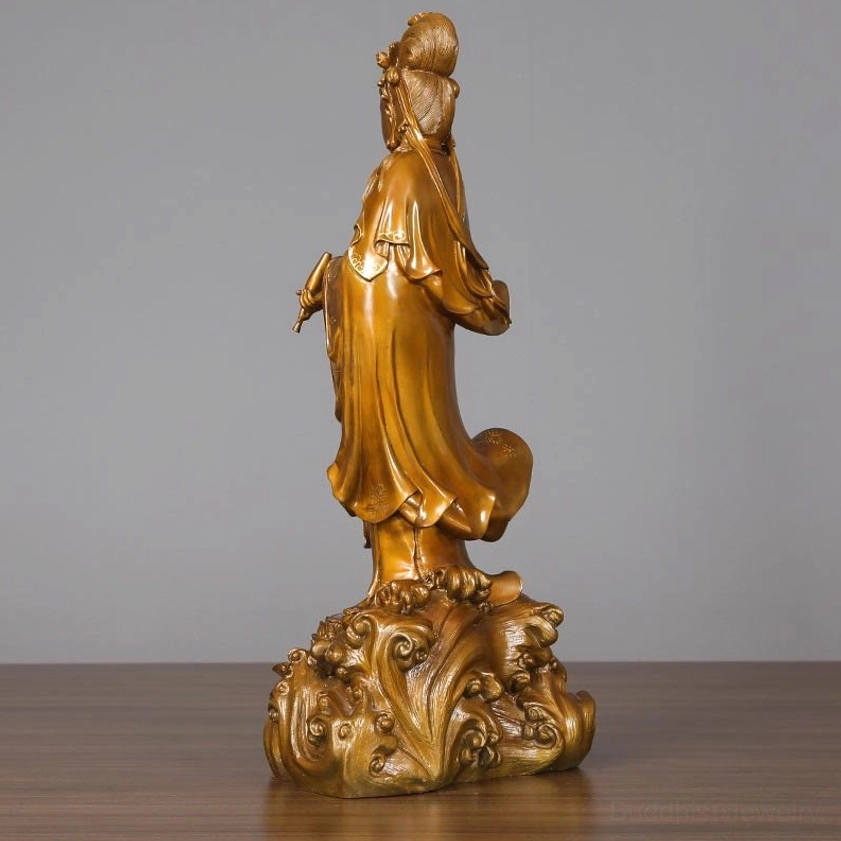 Rear left three-quarter view of Guan Yin bronze statue showing intricate carved draped robes and ornate lotus base