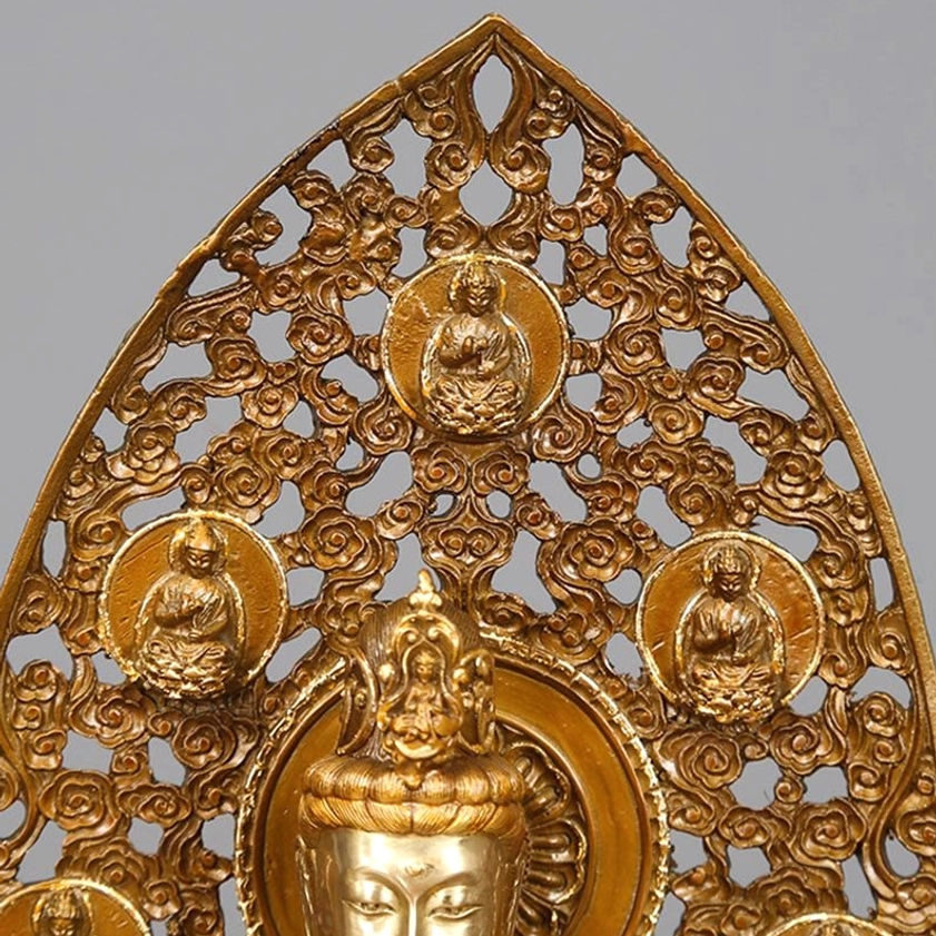 Guanyin statue backplate lower section close-up - polished bronze relief carvings of celestial buddhas and lotus motifs