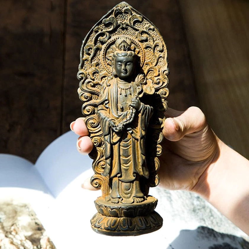 Handheld Guanyin Buddha statue with lotus base and weathered rust texture, showing detailed carving and spiritual craftsmanship of Buddhist trinity figurine