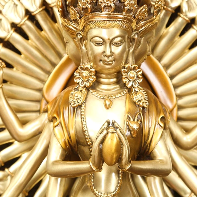 Guan Yin deity close-up showing serene face with adorned jewelry necklaces and sacred relic in hands