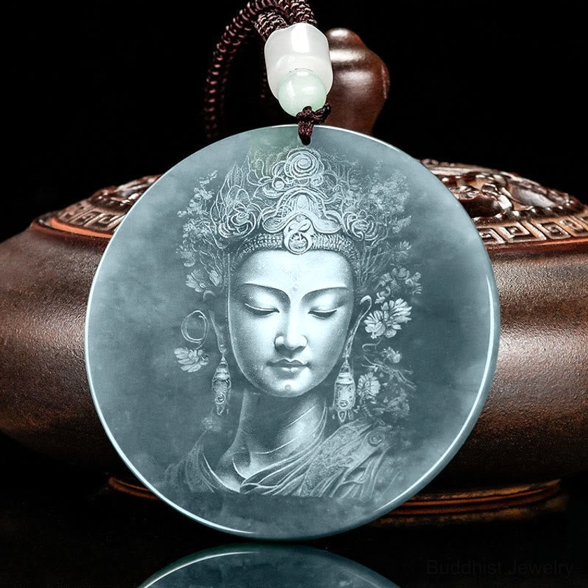 Guanyin pendant with black braided cord and jade beads on wooden base
