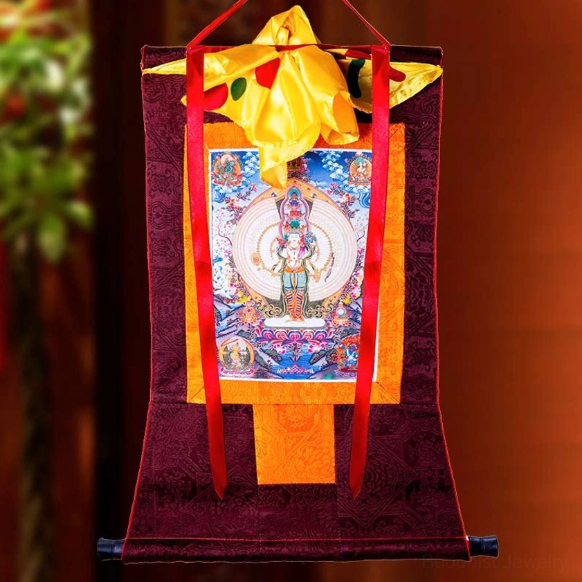 Hand-painted Guanyin thangka with red satin brocade frame in warm-toned interior with green plants