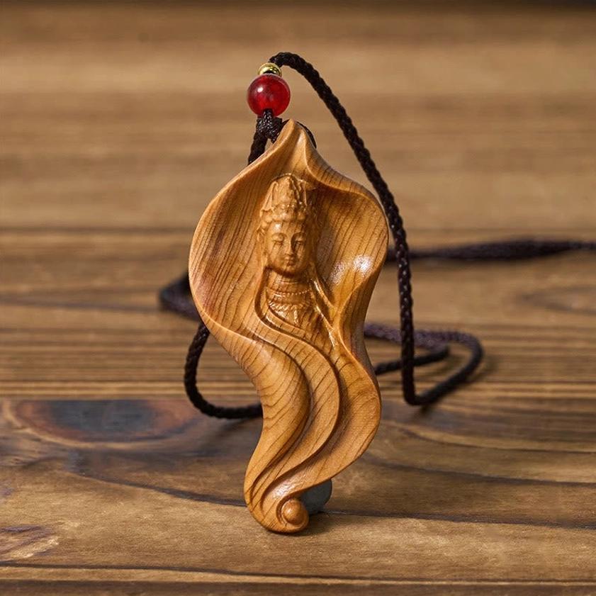 Handcrafted Guanyin wood pendant with three-quarter angle showing intricate carving and red glass bead accent