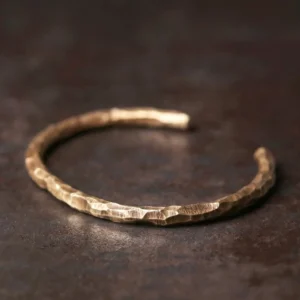 Hammered brass cuff bracelet top view, showing intricate textured surface and open-ended design for prosperity and spiritual balance