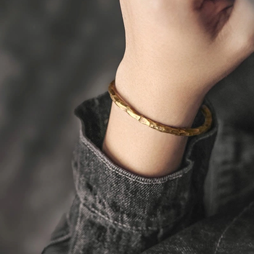 Hammered brass prosperity cuff bracelet with intricate textured bumps, representing Buddhist spiritual abundance and protection symbolism