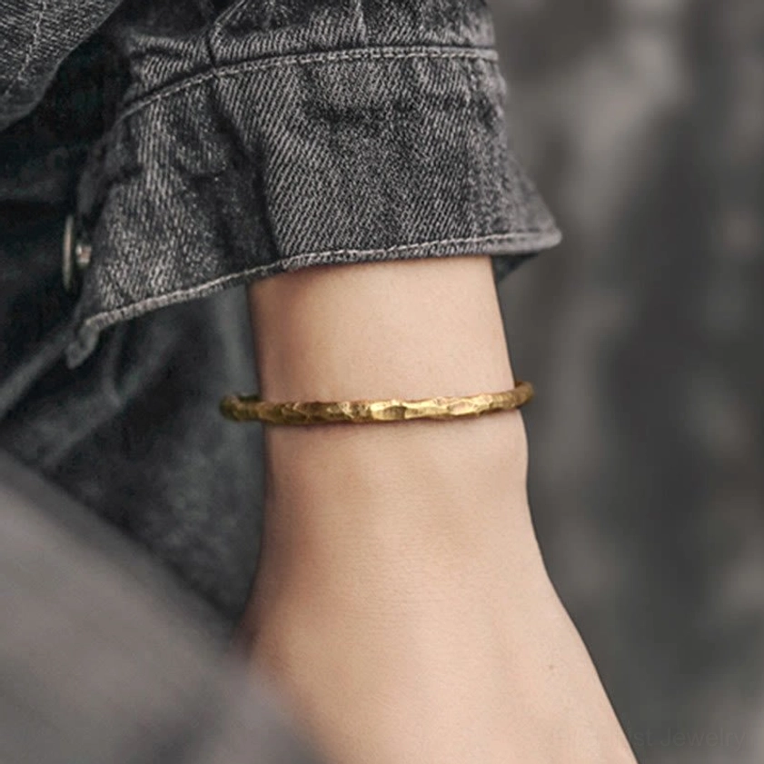Hammered brass cuff bracelet worn on wrist side view, displaying comfortable fit and textured gold tone aesthetic for spiritual practice