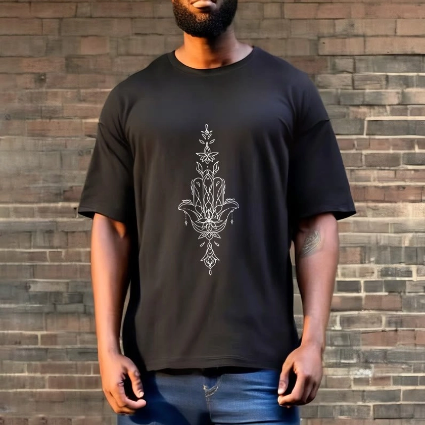Male model wearing black hamsa lotus Buddhist t-shirt full front view brick wall outdoor setting with denim bottoms