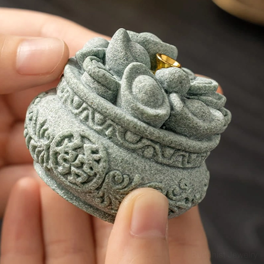 Buddhist sandstone incense burner detail showing hand-carved auspicious symbols and texture