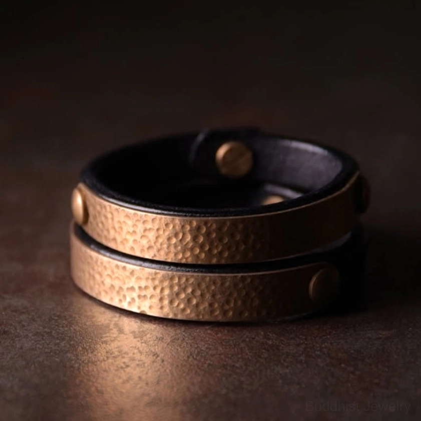 Hand-dyed leather bangle with brass hardware representing Buddhist abundance and good fortune symbolism