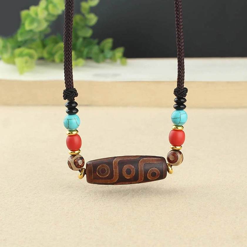 Hand-painted natural agate dzi bead necklace detail showing intricate Buddhist symbolic patterns and craftsmanship