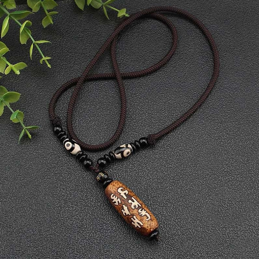 Authentic hand-painted Dzi bead agate stone showing natural variations and Buddhist mantra Sanskrit carving
