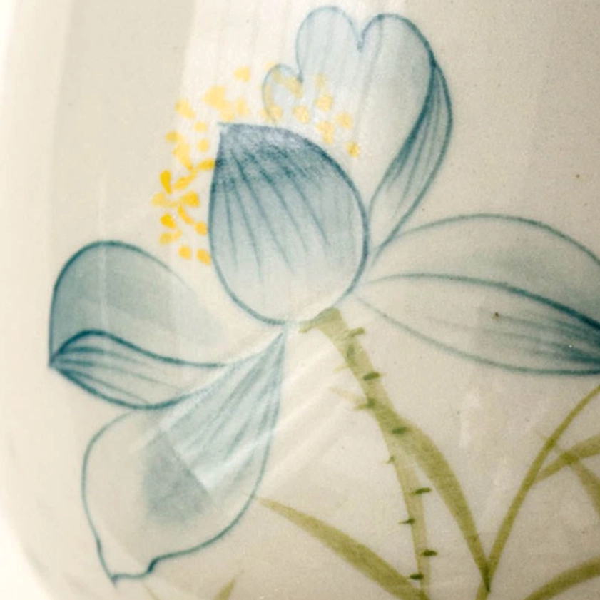 Macro view of hand-painted lotus petals and stamen showing traditional brush technique and ceramic glaze texture