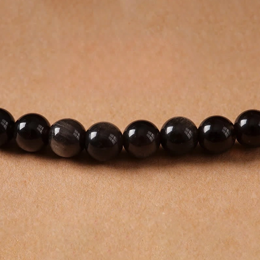 Silver Sheen Obsidian Buddhist protection necklace featuring hand-woven black beads and metal accents