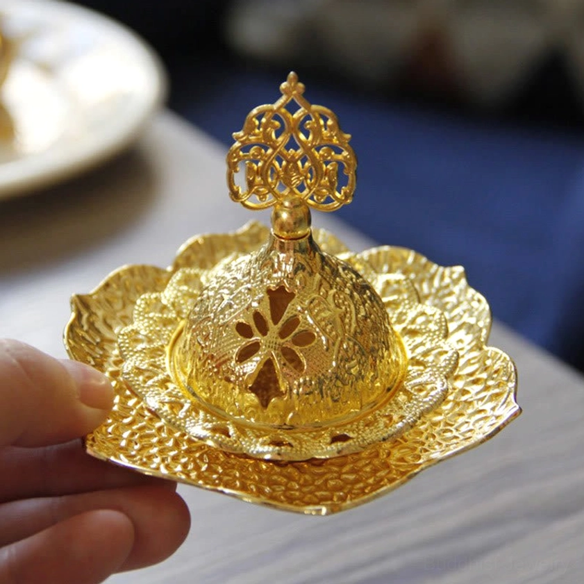 Hand-held Buddhist incense burner showing ornate carved top finial and detailed craftsmanship