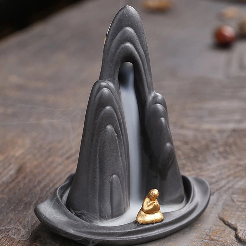 Handcrafted ceramic mountain incense burner displaying layered texture and artistic monk detail