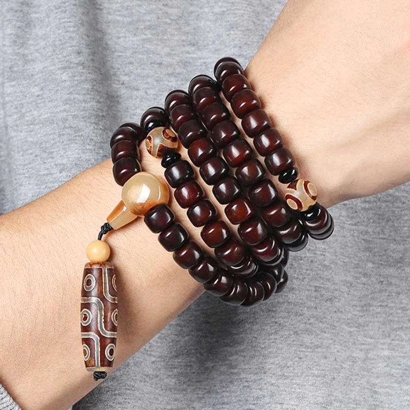 Handcrafted Buddhist mala bracelet with 108 beads including dzi stones, bodhi seeds, and jade showing authentic spiritual jewelry craftsmanship