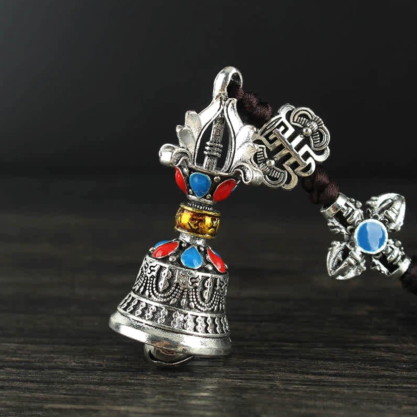 Detailed view of Buddhist handcrafted car ornament showing intricate Vajra bell and sacred symbol work
