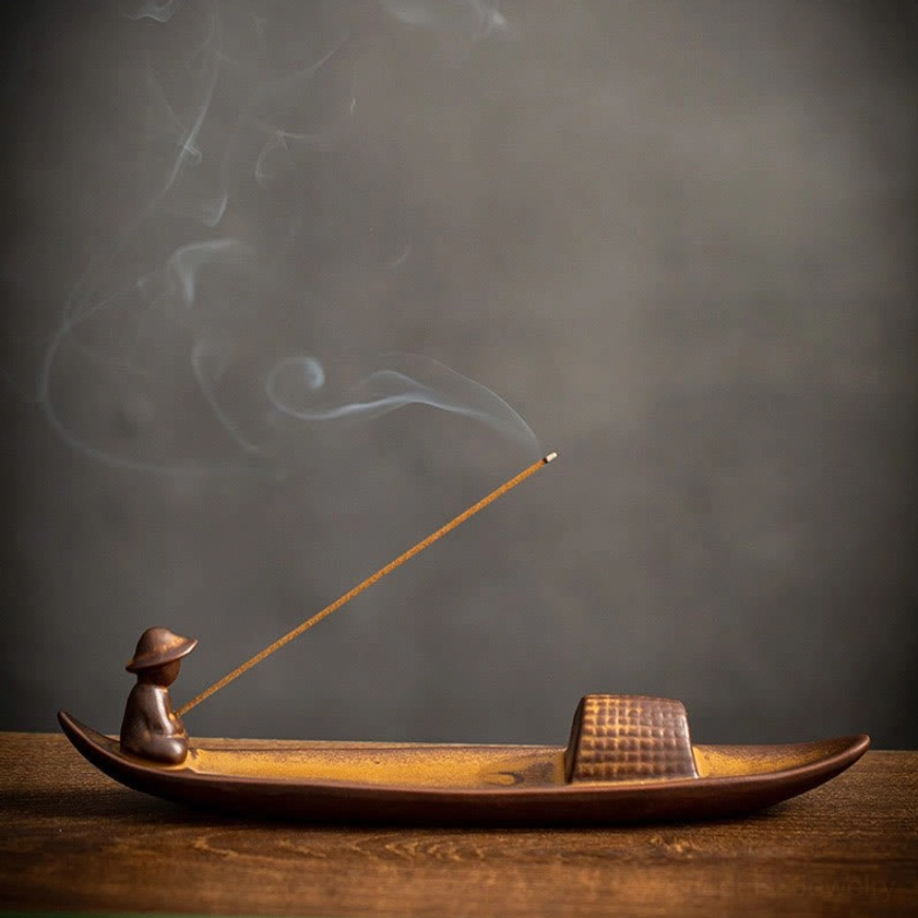 Ceramic incense burner with warm brown finish showing rising fragrant smoke in close-up detail
