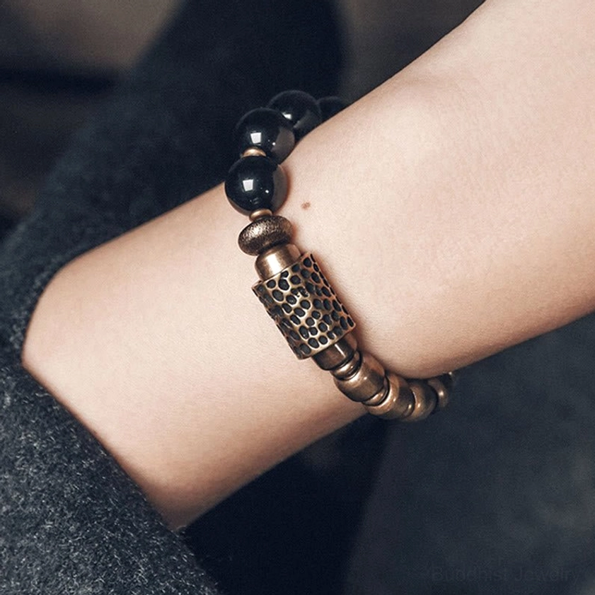 Handcrafted healing bracelet featuring lava rock, rainbow obsidian and brass, showing premium elastic string cord