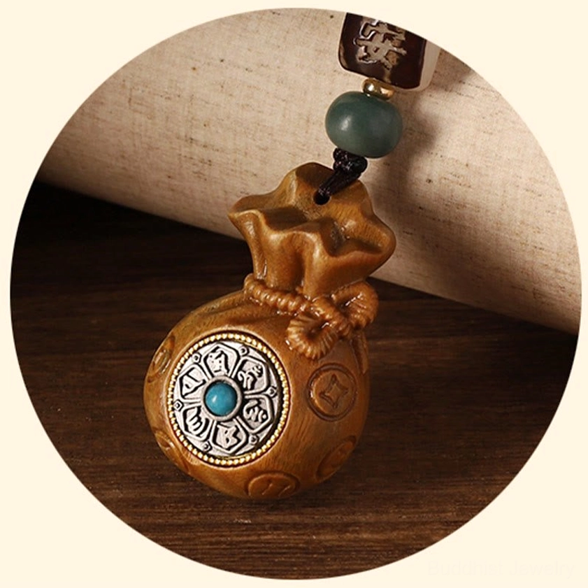 Buddhist charm craftsmanship detail showing hand-carved money bag silhouette and intricate bead work on sandalwood pendant