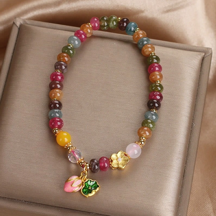 Handcrafted tourmaline lotus wisdom bracelet featuring mixed color beads, premium elastic cord, and pink lotus bud pendant
