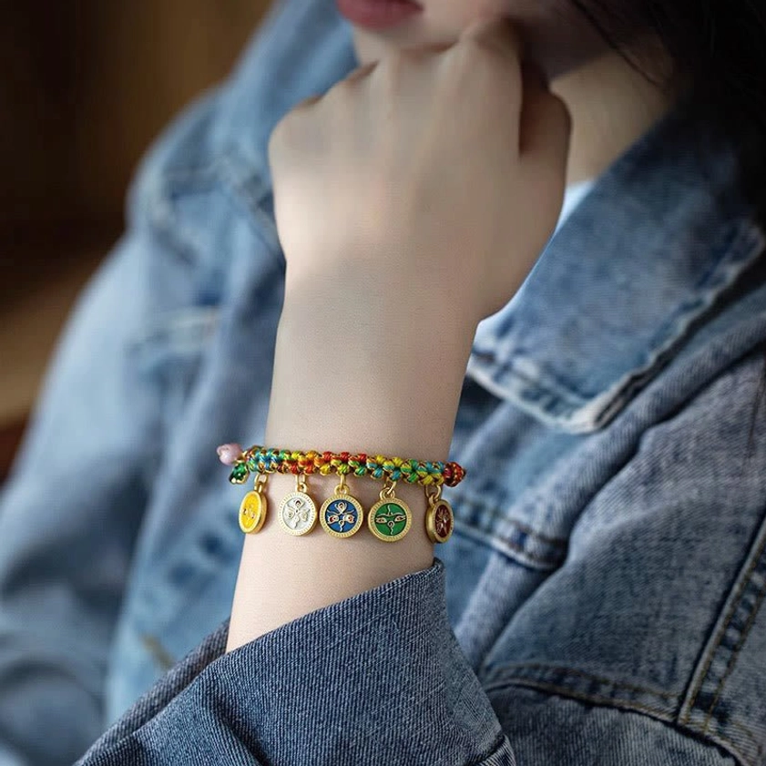Artisan working on Five Gods of Wealth bracelet, tying braided red cord with white beaded knot, showcasing handcrafted Buddhist jewelry-making process