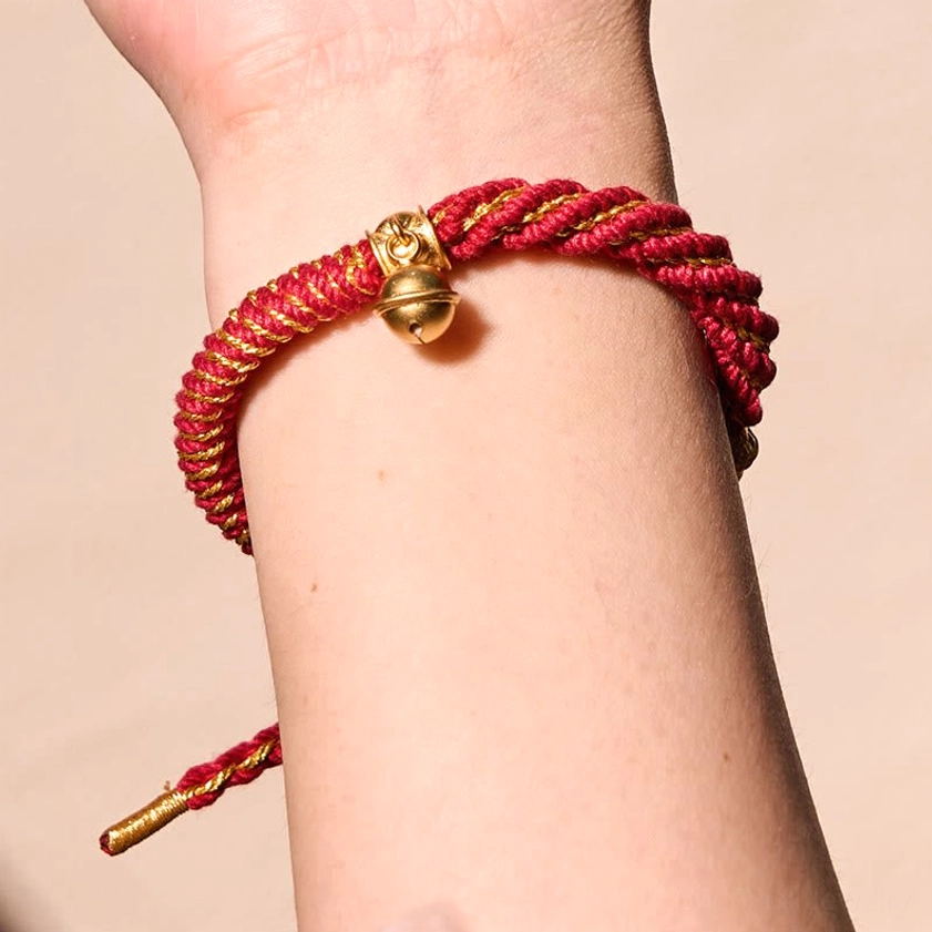 Handmade Buddhist string bracelet featuring multicolor woven cord with Ghau prayer box and protective metal charms