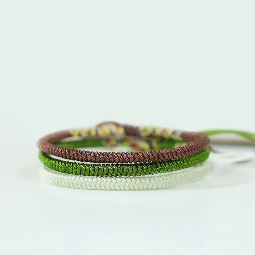 Buddhist bracelet trio with adjustable cord ends, showing authentic handwoven King Kong Knot design in brown, white, and dark green