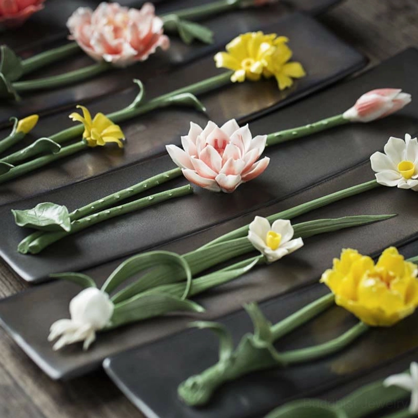 Multiple handcrafted ceramic floral incense burners in various colors displayed on tabletop, collection showcase